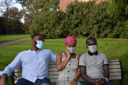 Black international students (Class of 2021) laughing on a bench